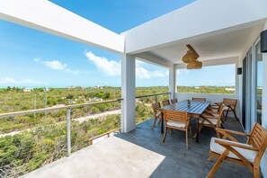 Enjoy dining al fresco with a view of the coastal landscape from this outdoor balcony.