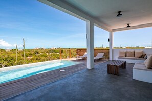 Relax in a serene outdoor oasis with a pool, lounge chairs, and comfortable seating area.
