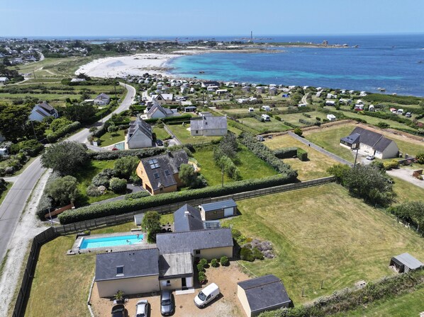 A coastal residential area with houses, a swimming pool, and a beach. - 4-star villa, 230 m², heated pool, steam room, ocean view, beach 200 m away—sleeps 8. (Plouguerneau)