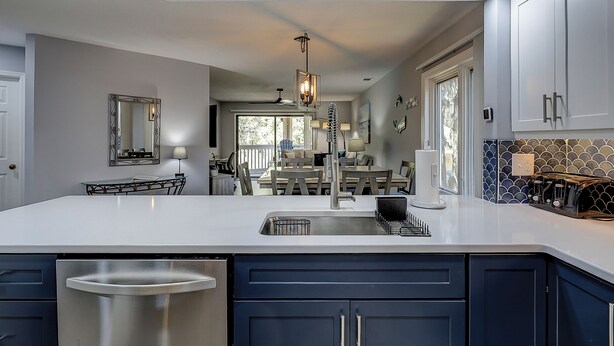 A modern kitchen with a large island, stainless steel appliances, and a dining area with a view. - 174 Colonnade Club - Shipyard - 2 Bed 2 Bath Sleeps 5 - Hilton Head Rentals (Hilton Head Island)
