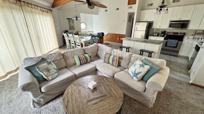 Una sala de estar con un sofá modular, una mesa de centro y un comedor con sillas y una mesa.