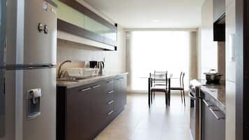 Una cocina moderna con refrigerador, estufa y comedor.
