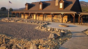 Una cabaña con fachada de piedra, vigas de madera y un patio cubierto.