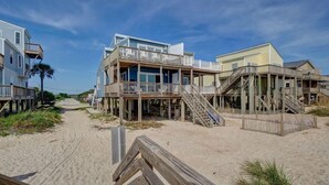 A beachfront property with multiple wooden decks and a sandy walkway. - Oceanfront Duplex with unobstructed ocean views! (North Topsail Beach)