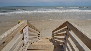 A wooden staircase leading to a beach with a sign on the left. - Oceanfront Duplex with unobstructed ocean views! (North Topsail Beach)