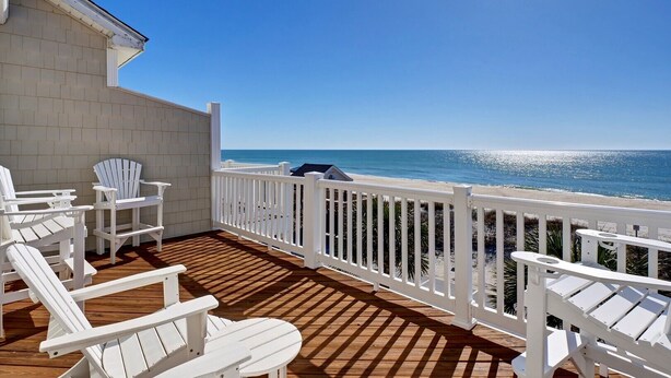 A wooden deck with white Adirondack chairs overlooking a beach. - Unobstructed Ocean Views!  4 Bedroom townhouse, beach access, community pool (Surf City)