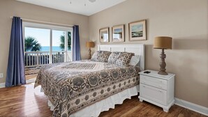 A bedroom with a large bed, a nightstand, a ceiling fan, and a view of the ocean. - Unobstructed Ocean Views!  4 Bedroom townhouse, beach access, community pool (Surf City)