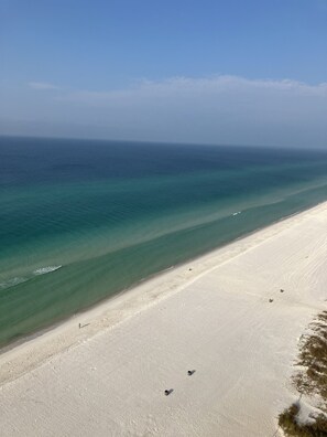A beach with clear turquoise waters and a wide sandy shore. - Quiet, Beach Facing Master Bedroom! Spectacular Views! (Panama City Beach)