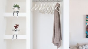 A white wardrobe with shelves, a hanging rod, and a basket. - Vista sulle Cupole by Wonderful Italy (Palermo)