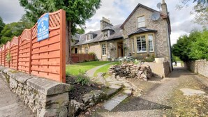 A stone house with a stone driveway and a wooden fence.