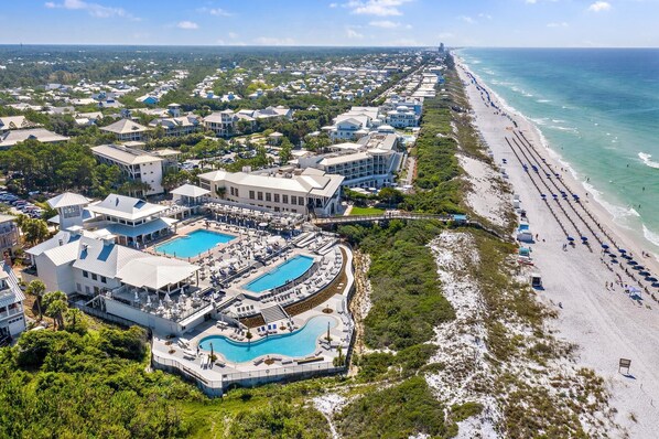 An aerial view of a coastal resort with multiple swimming pools, beachfront access, and a long sandy beach. - Close to the Town Center and the Beach (Santa Rosa Beach)