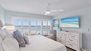 A bedroom with a large bed, a ceiling fan, a dresser, and a view of the beach through large windows. - TOP FLOOR GULF FRONT UNIT!! B1404 PANAROMIC VIEW OF GULF OF MEXICO! (Destin)
