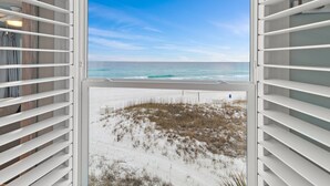 A room with a large window overlooking a beach and dunes. - TOP FLOOR GULF FRONT UNIT!! B1404 PANAROMIC VIEW OF GULF OF MEXICO! (Destin)