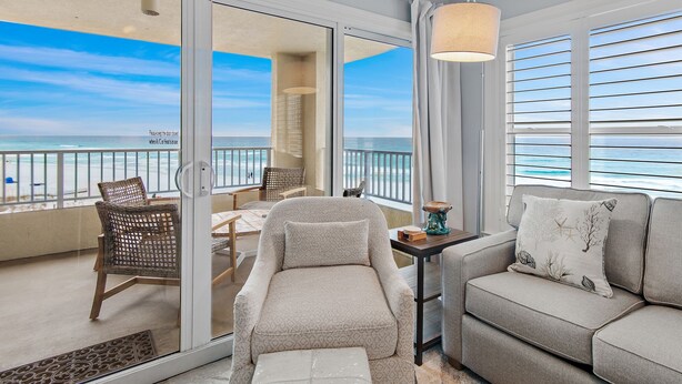 A balcony with a view of the ocean, furnished with a sofa, chairs, and a small table. - TOP FLOOR GULF FRONT UNIT!! B1404 PANAROMIC VIEW OF GULF OF MEXICO! (Destin)