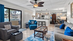 A spacious living room with a ceiling fan, a dining area, and a kitchen.