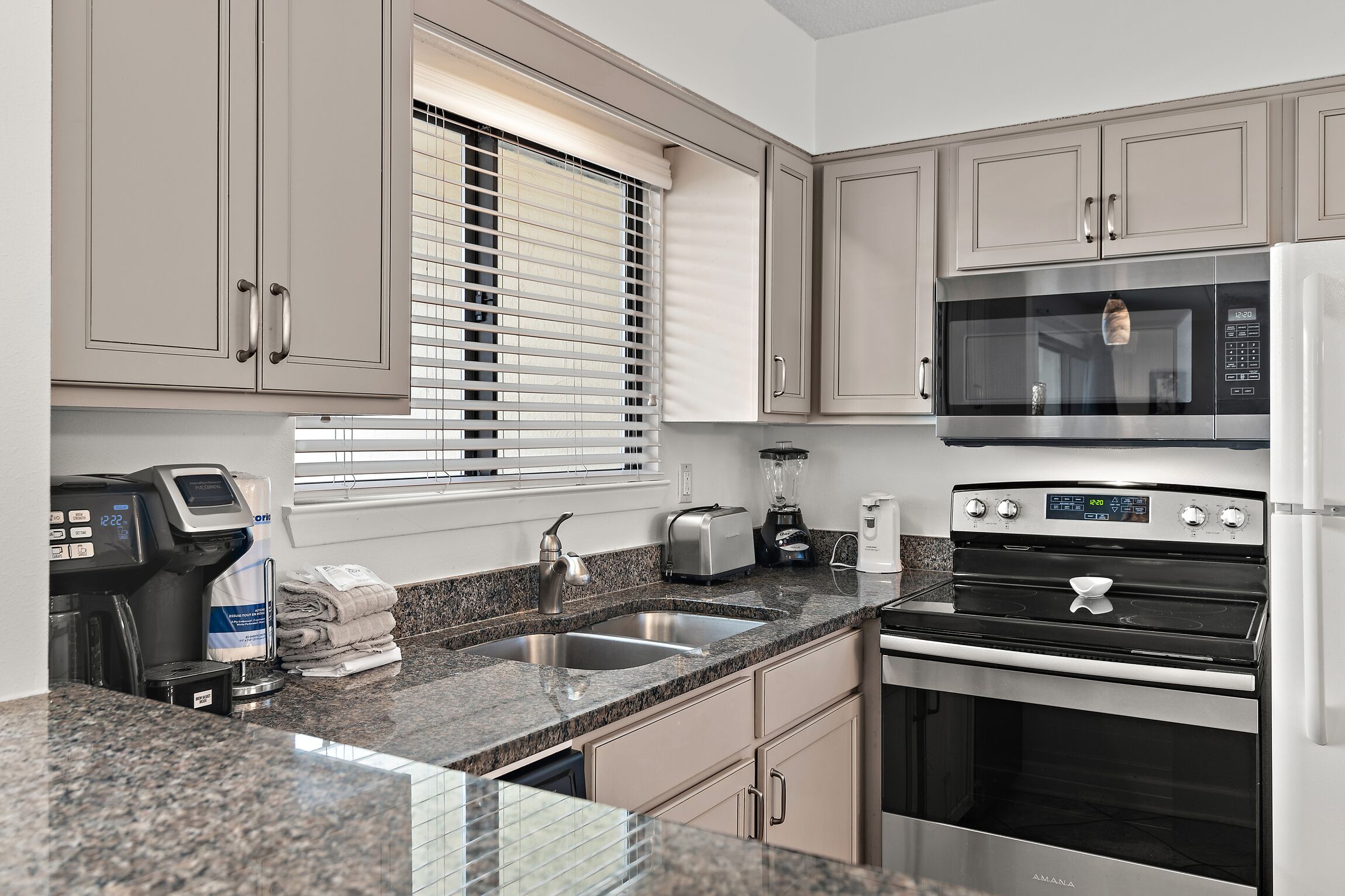 A modern kitchen with a built-in microwave, oven, and coffee maker.
