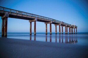 Sturdy pier extends into the calm water, supported by multiple pillars.