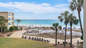Ein Strandhotel mit Poolbereich, direktem Zugang zum Strand und Palmen.
