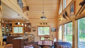 L’intérieur d’une cabane est doté d’un plafond en bois, d’un coin repas, d’une cuisine et de grandes fenêtres.