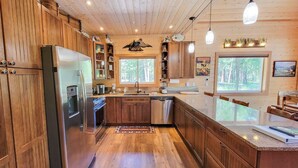 Une cuisine moderne avec des meubles en bois, des appareils électroménagers en acier inoxydable et une grande fenêtre.