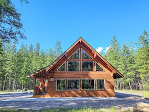 A wooden cabin with a gabled roof, large windows, and a porch area. - Nordic Village Cabin in the heart of Mazama (Mazama)