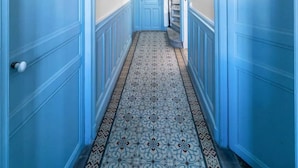A hallway with blue doors and a patterned carpet.