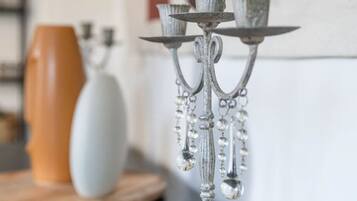 Un chandelier en argent, orné de trois bougeoirs, est posé sur une table en bois.