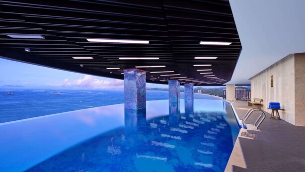 An infinity pool with a view of the sea, supported by pillars, and a modern ceiling design. - Wyndham Grand Plaza Royale Shuangyue Bay (Huizhou)