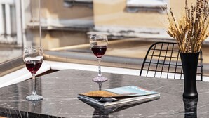 A marble table with two wine glasses, a magazine, and a vase with dried plants. - Galata Door Otel (Istanbul)