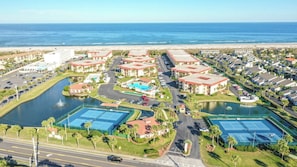 Um resort com vários edifícios, uma praia e um porto de iates.