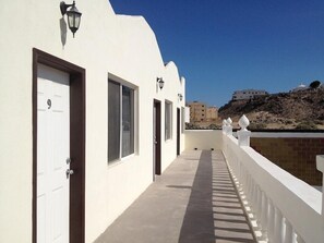 Guest rooms line the corridor, each with a door and a window.