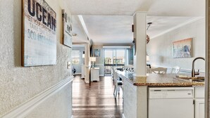 Cucina con piano di lavoro in granito, mobili bianchi e vista esterna.