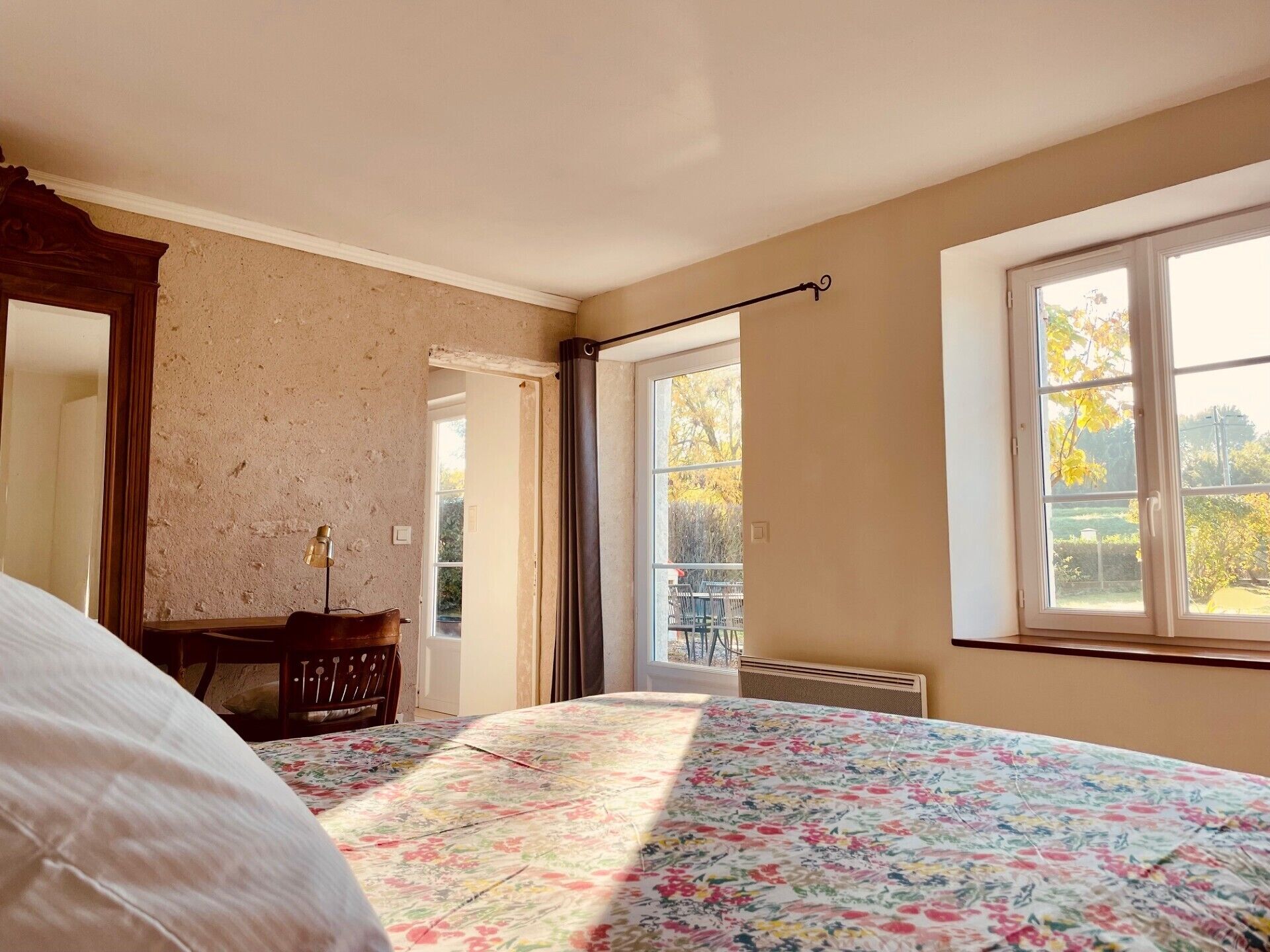 A bedroom with a bed, a dresser, a window, and a door.
