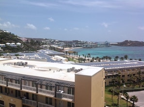 A coastal hotel with multiple floors, a rooftop pool, and a view of the beach and ocean.