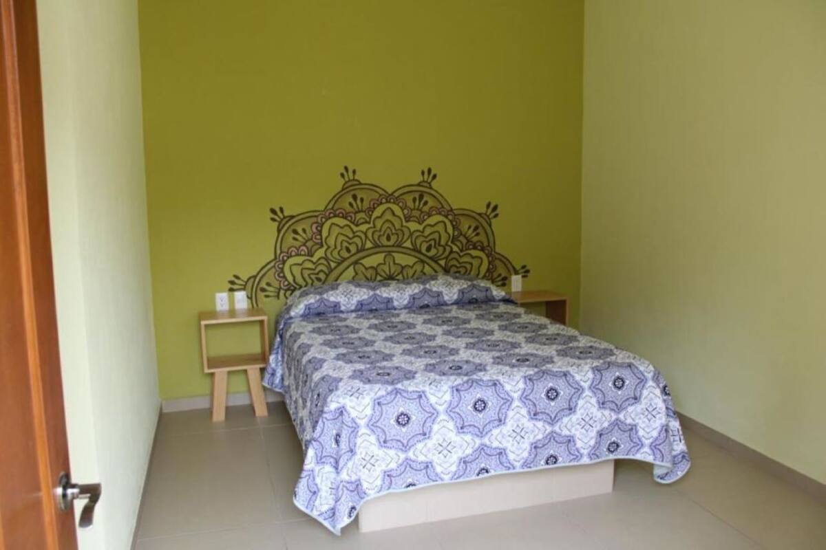 A bedroom with a bed, a nightstand, and a small table.