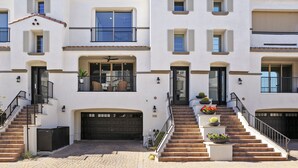 A multi-story residential building with a central staircase, balconies, and a garage. - Luxury Rental by The Princess  (Scottsdale)