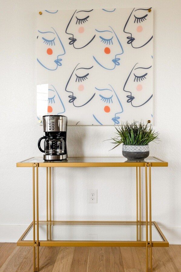 A coffee maker on a glass-top table with a potted plant beside it. - Bachelor/Bachelorette Mansion In the Heart of ATX (Austin)