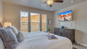 A bedroom with a large bed, a ceiling fan, a dresser, and a painting on the wall. - Escondido 2275, Sleeps 20, Ping Pong Table, BBQ - near Sand Hollow, and Quail Creek (Washington)