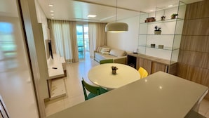 Une cuisine moderne avec une table de salle à manger ronde, une bibliothèque intégrée et une porte-fenêtre coulissante donnant sur un balcon.