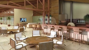 Un hall d’entrée spacieux avec un espace salon central, un bar et un écran de télévision.