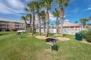 A hotel with a pool, palm trees, and a fenced area. - Atlantis 204B (St. Augustine Beach)