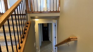 Una escalera con barandillas de madera y un rellano alfombrado.