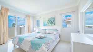 Une chambre moderne avec un grand lit, un balcon et une vue sur la ville.