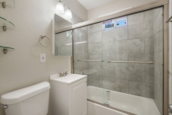 A bathroom with a glass-enclosed shower, a white sink, and a toilet. - WL1- Modern 2BR Retreat Minutes from Downtown & Top SA Attractions (San Antonio)