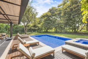 An outdoor swimming pool with lounge chairs and a wooden deck.