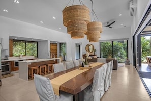 A modern kitchen with a central island, pendant lighting, and a view of the outdoors.