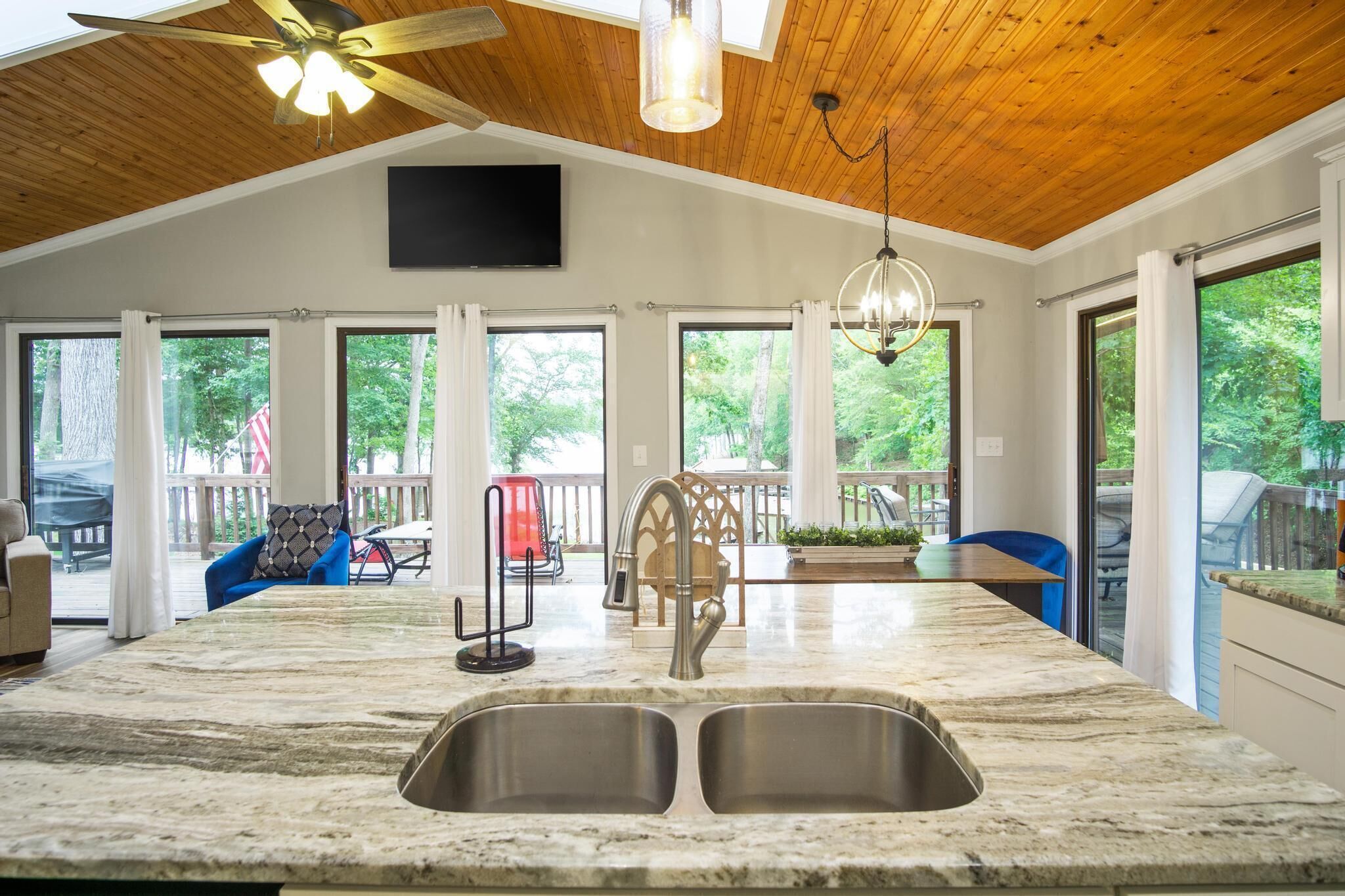 Una cocina amplia con una isla grande, doble pileta y ventilador de techo.