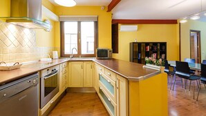 A compact kitchen with a built-in oven, microwave, and a large window. - Apartamento San Vicente by Toledo AP (Toledo)