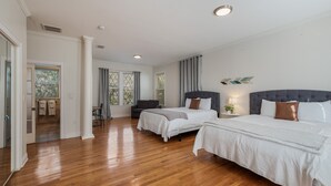 Ein geräumiges Schlafzimmer mit zwei Betten, einer Sitzecke und Blick ins Freie.