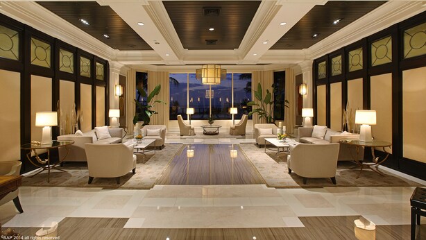 A spacious lobby with a central seating area, large windows, and a chandelier. - Luxury Condo in the Ritz Carlton Residences on a private beach  (Riviera Beach)